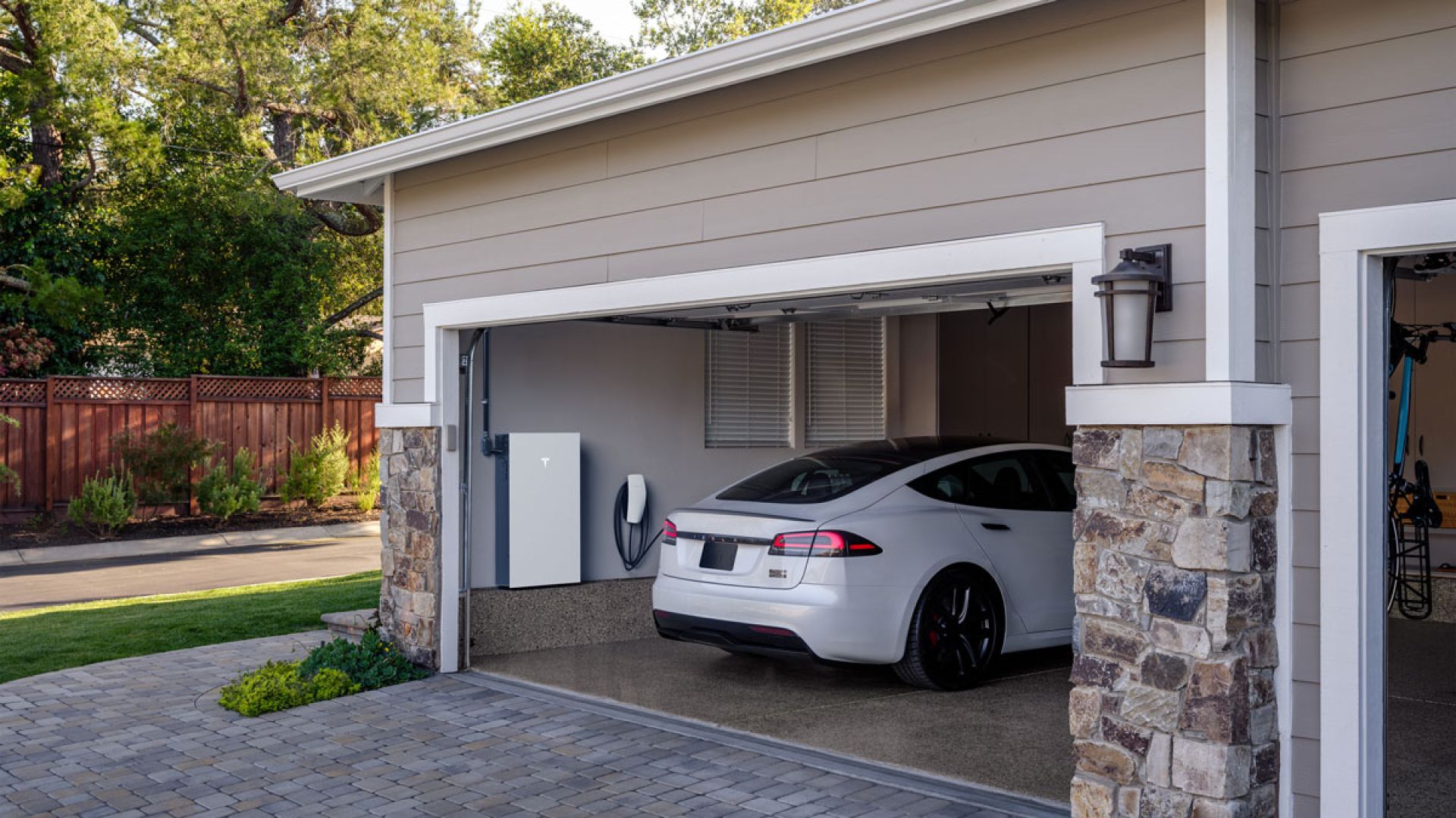 Tesla sedan charging in residential garage